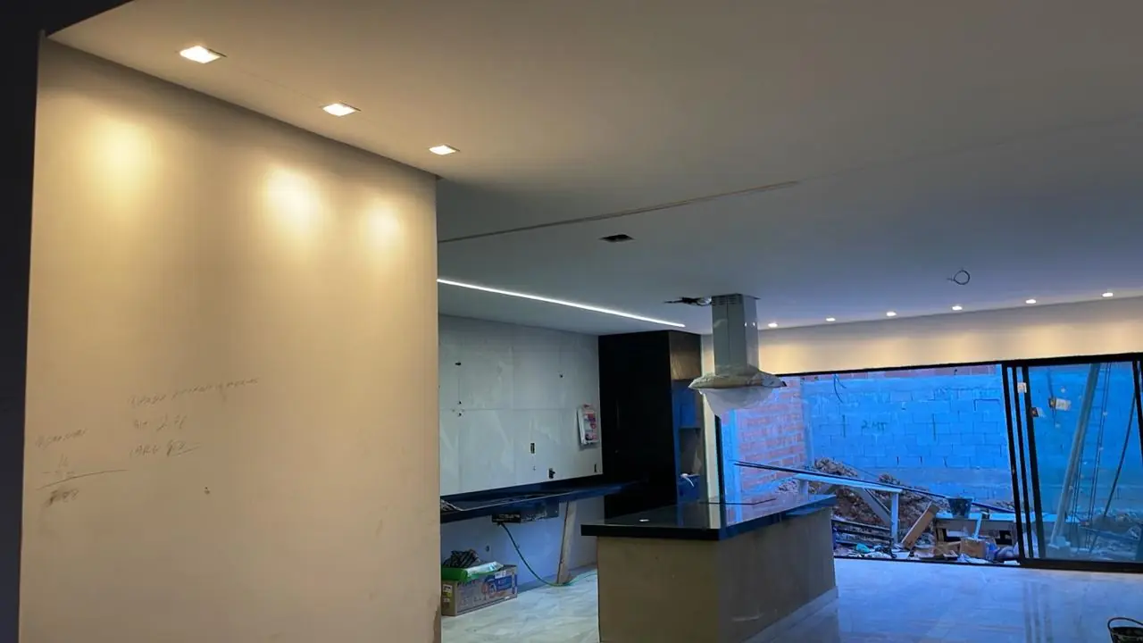 Ambiente residencial renovado com cozinha integrada e iluminação
