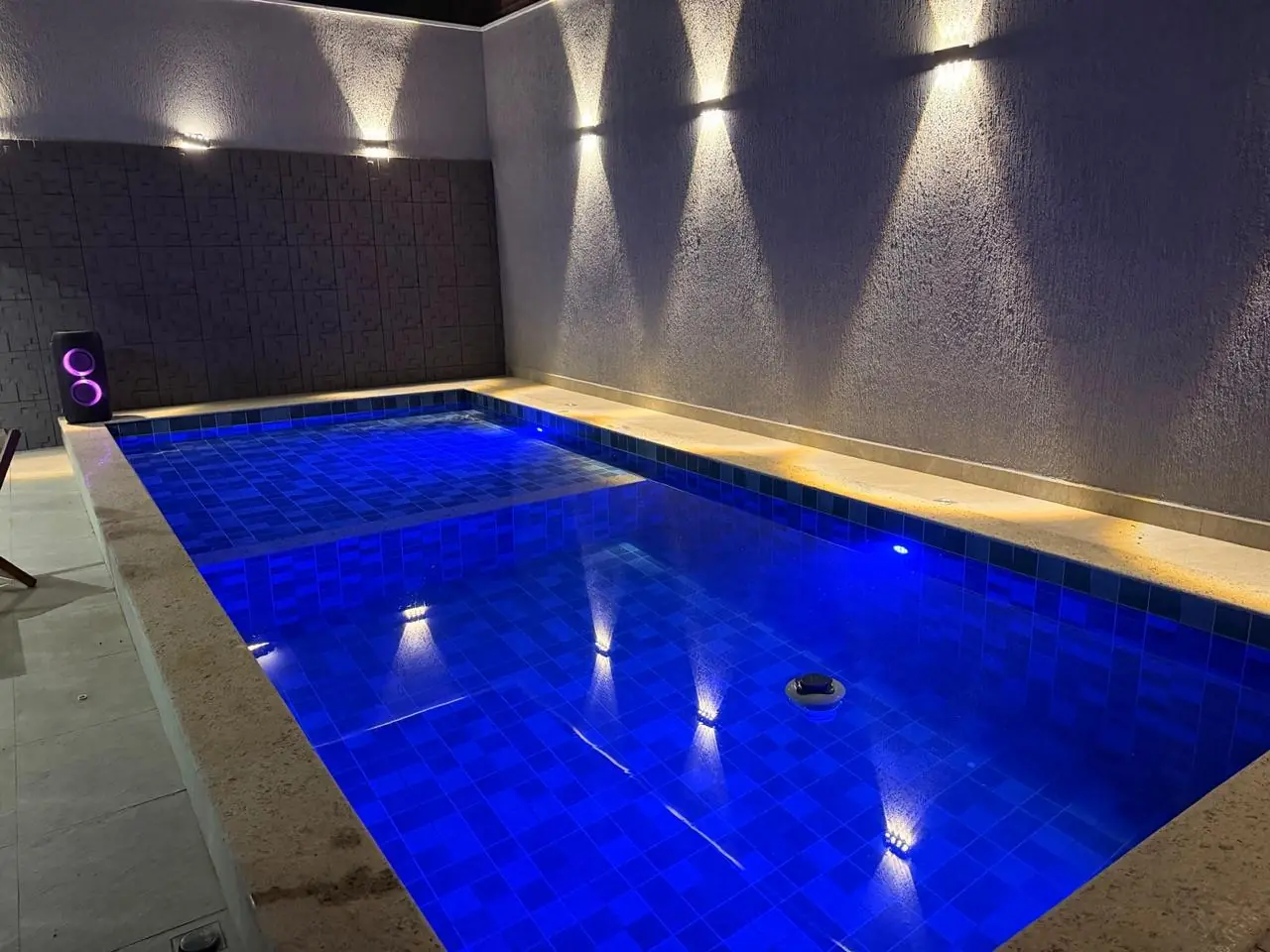 Piscina concluída com revestimento, iluminação e área de circulação